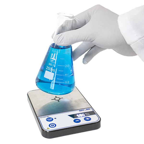 BenchMate Magnetic Stirrer by Oxford Lab Products with a lab glove holding a flask of blue liquid.