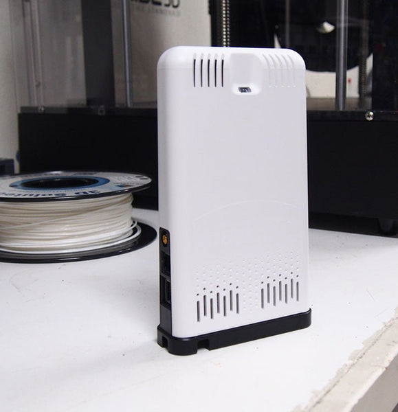 White EnviroMonitor IP Gateway by Davis Instruments with ventilation slots, standing on a white surface.
