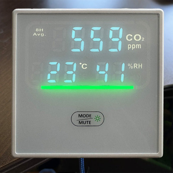Hardwired CO2, humidity, and temperature IAQ monitor from Sper Scientific, displaying measurements on a digital screen with a horizontal green light indicator.
