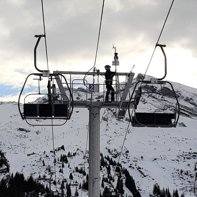 Mounting pole kit for weather stations by Davis Instruments, being inspected on a chairlift pylon during the winter.