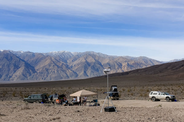 Accessory mounting tripod by Davis Instruments against a desert landscape and blue sky.