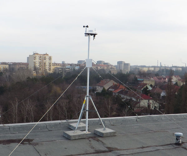 Mounting tripod by Davis Instruments set up on a rooftop with a meteorological sensor attached.