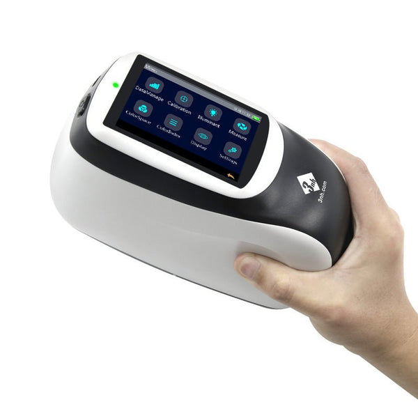 White and black spectrophotometer by 3nh being held in a hand against a white background.
