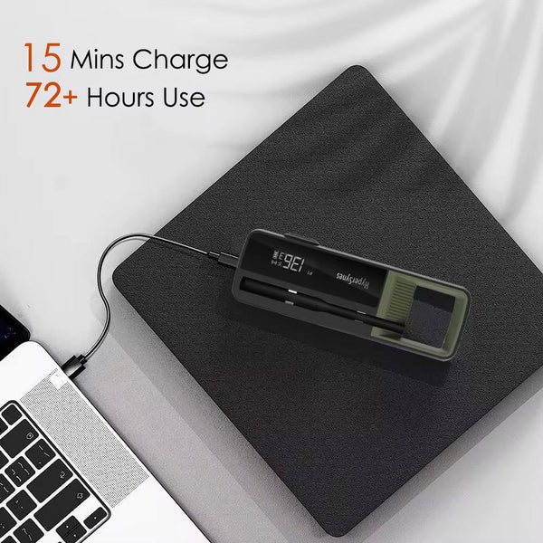 Black smart thermometer by Sper Scientific on a gray surface, charging with a laptop nearby.