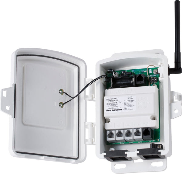 White wireless sensor transmitter by Davis Instruments inside an open weatherproof enclosure, with antenna, circuit board, and ports visible.
