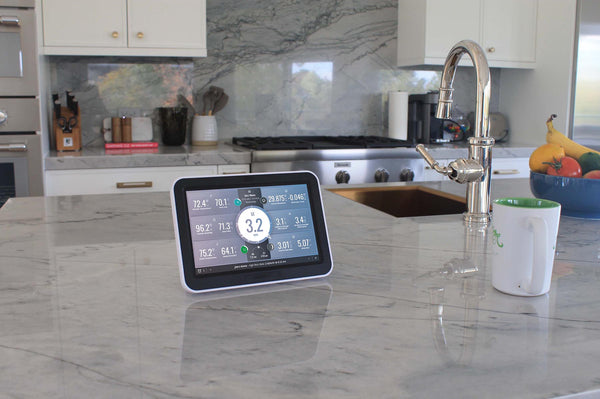 Data viewing console by Davis Instruments showing detailed weather information on a marble countertop in a kitchen.

