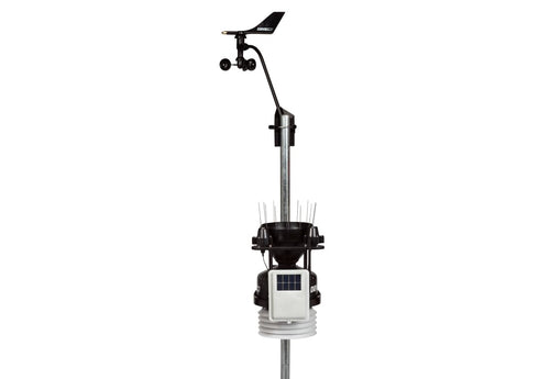 Wireless weather station by Davis Instruments with wind vane and solar panel on a metal pole.
