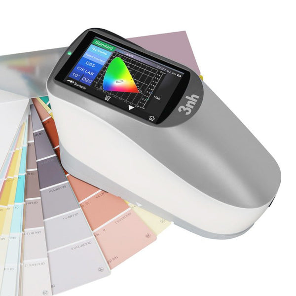 Portable spectrophotometer, YS45 series, by 3nh, showing a color spectrum chart on its display screen and surrounded by paint swatches.
