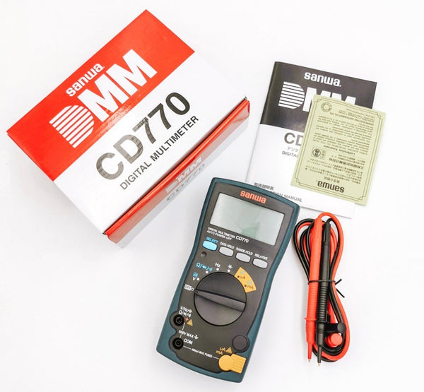 Blue and gray multimeter by Sanwa with included instruction manual, certificate of calibration, test leads, and box.