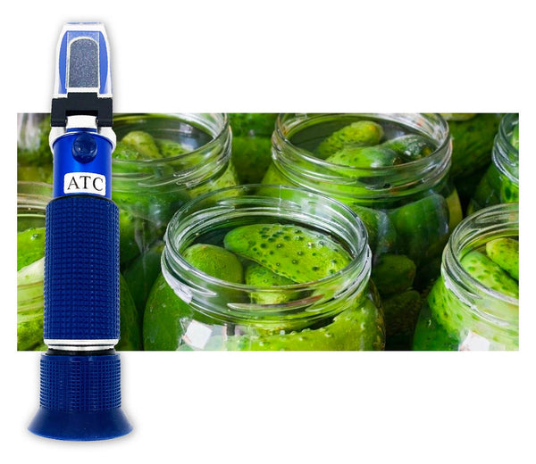 Salinity refractometer by Sper Scientific with blue handle, next to jars of pickled cucumbers.
