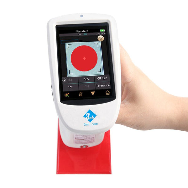 Handheld spectrophotometer by 3nh with a red test reading displayed on the screen.
