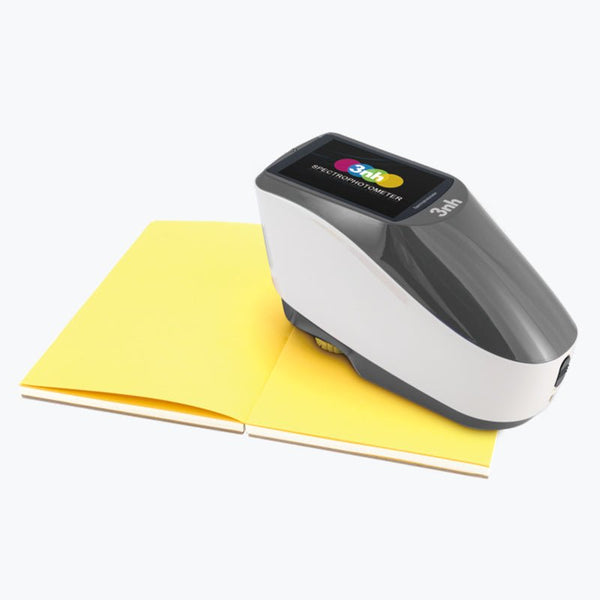 Portable spectrophotometer by 3nh on top of a yellow color palette.